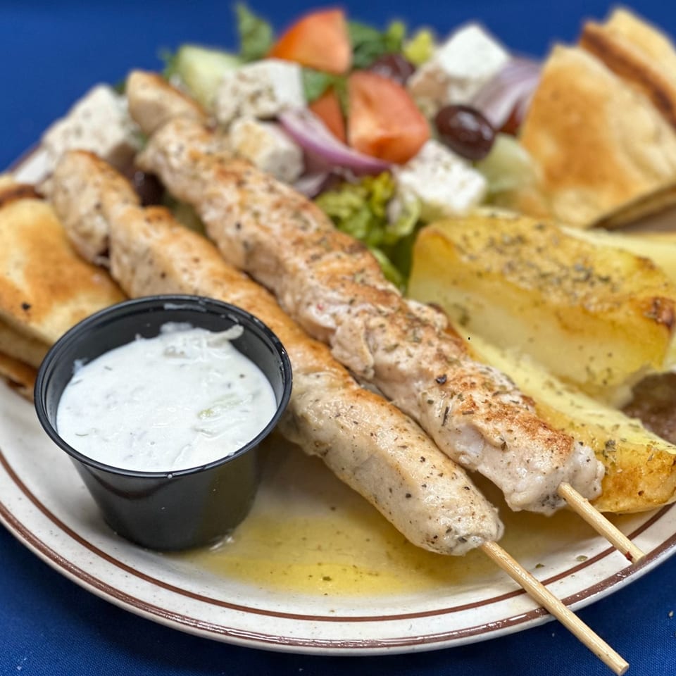 Opa Greek Restaurant's chicken souvlaki with roasted potatoes, Greek salad, pita bread, and tzatziki sauce.