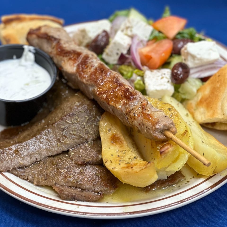 Opa Greek Restaurant's platter with gyro meat, souvlaki, roasted potatoes, Greek salad, pita, and tzatziki.