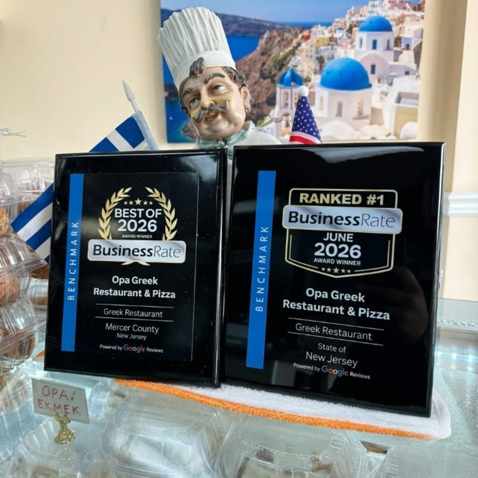 Two black award plaques for Opa Greek Restaurant & Pizza, with a chef figurine and Greek flag.